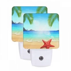 Night Light Set Of 2, A Red Starfish Is Sitting On The Beach In Front Of The Ocean.
