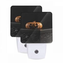 Night Light Set Of 2, A Carved Pumpkin Is Sitting On A Black Box.