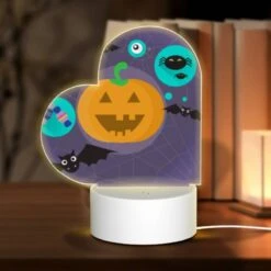 Love Acrylic Night Light, A Pumpkin Is Surrounded By Bats And Other Halloween-themed Items.