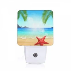 Night Light, A Red Starfish Is Sitting On The Beach In Front Of The Ocean.