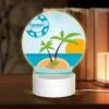 Round Acrylic Night Light, A Palm Tree Is Growing On A Small Island In The Middle Of The Ocean.
