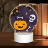 Round Acrylic Night Light, A Black Cat And A Pumpkin Are Among The Halloween Decorations.